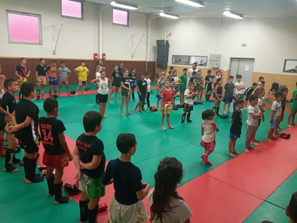 Le cours enfants : une quarantaine d'enfants et d'adolescents alignés sur les tapis, en tenue de boxe thaï, avant le début de la séance.